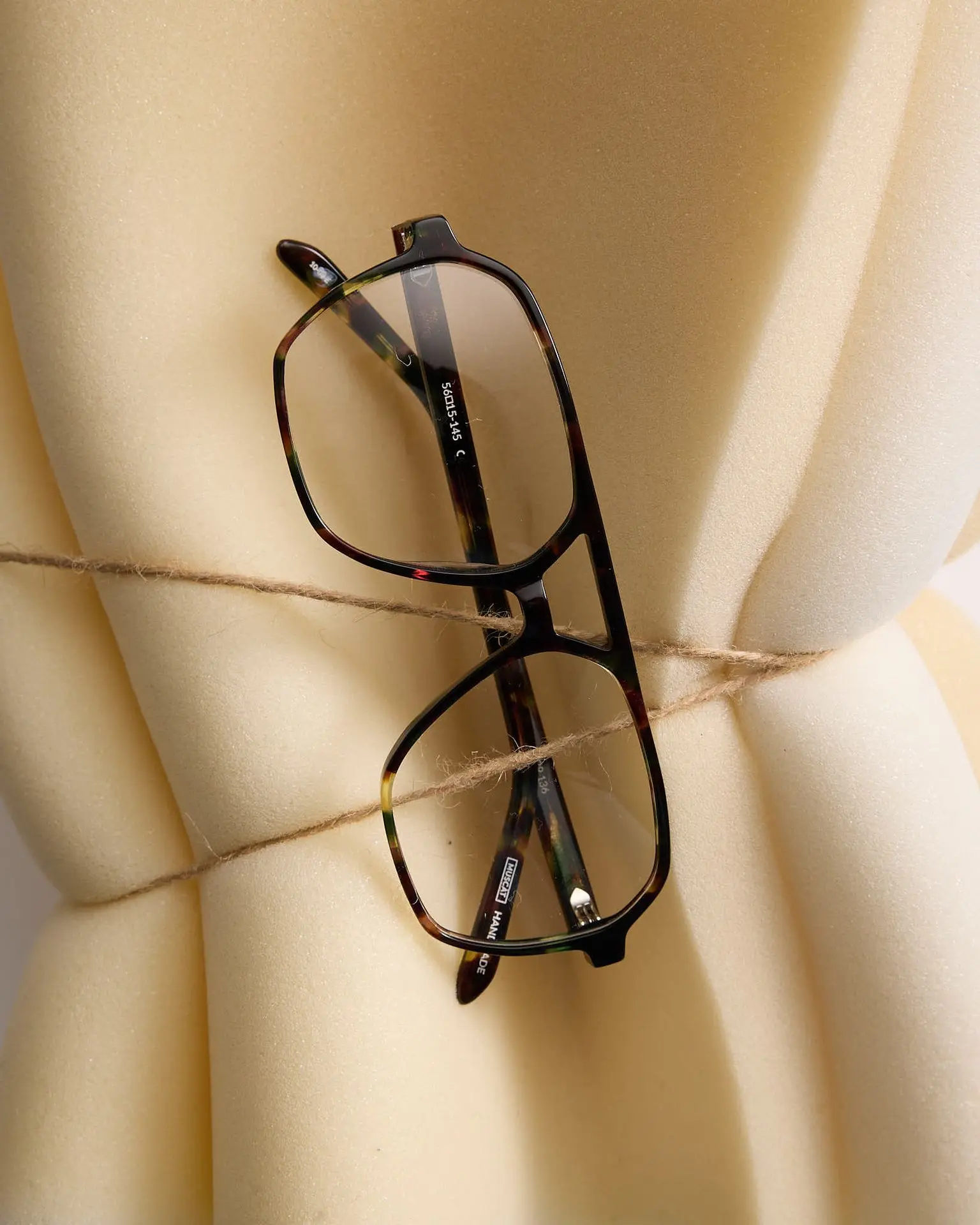 Powłoka antyrefleksyjna (ang. Anti-Reflective coating, w skrócie AR) to ultracienka, wielowarstwowa struktura nanoszona na powierzchnię soczewki okularowej w komorze próżniowej. Jej zadaniem jest eliminowanie odblasków poprzez zjawisko interferencji światła - kolejne warstwy o precyzyjnie dobranych grubościach "wygaszają się" wzajemnie, dzięki czemu przez soczewkę przechodzi nawet 99,5% padającego światła. Łączna grubość całego stosu warstw to zaledwie kilkaset nanometrów - dlatego powłoka jest niezwykle wrażliwa na chemikalia i mechaniczne ścieranie [1].  W mojej codziennej pracy w produkcji soczewek MUSCAT widzę to na własne oczy: różnica między dobrze i źle pielęgnowaną powłoką AR jest dramatyczna już po kilku miesiącach użytkowania. To dlatego klienci, którzy inwestują w soczewki premium, a oszczędzają na ściereczce i płynie, najczęściej wracają z reklamacją po roku.